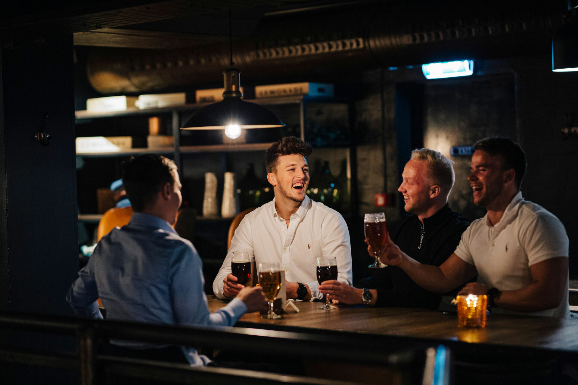 4 gutter som ler på bar